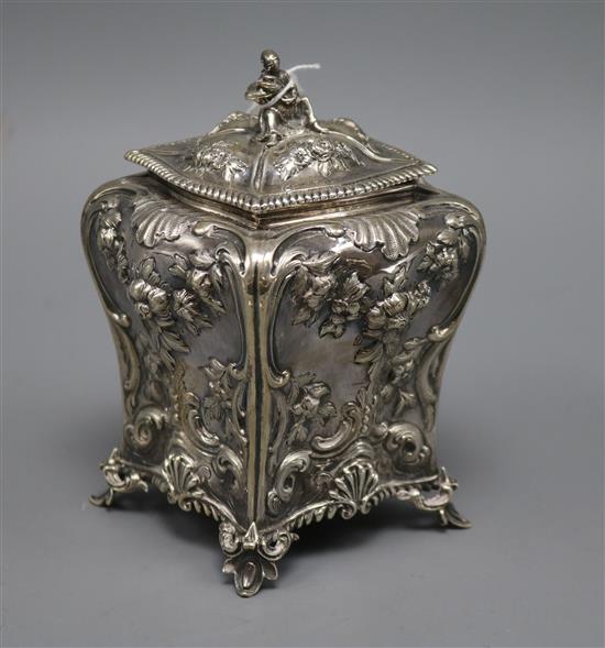 A Victorian embossed silver bombe shaped tea caddy, with figural finial, Charles Thomas Fox & George Fox, London, 1859, 10 oz.